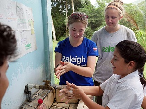 Charlotte (orange headband) helps teach children about sanitation